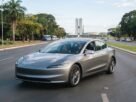 Carro elétrico circulando em Brasília com a Esplanada dos Ministérios ao fundo